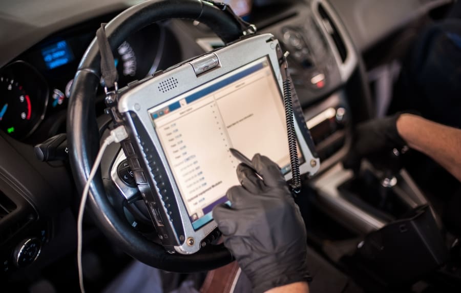 Técnico a ler códigos de erro com máquina de diagnóstico eletrónico ligada à porta OBD